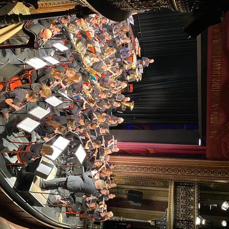 Man blickt in Vogelperspektive auf die Bühne des Parktheaters. Hier sitzt das Orchester der Sing- und Musikschule Mozartstadt Augsburg.