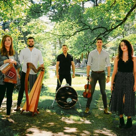 Die Band Billow Wood besteht aus fünf Mitgliedern. Sie stehen in einem Wald und blicken ernst in die Kamera. Sie haben ihre Instrumente, eine Harfe, eine Trommel, ein Geige, eine Flöte und ein Akkordeon bei sich.