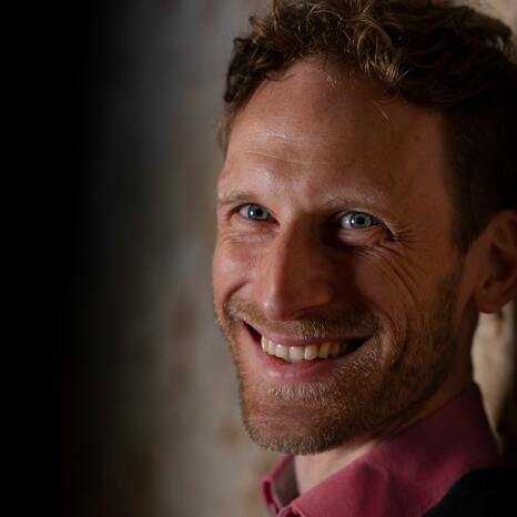 Portraitaufnahme von Yann Yuro. Er lacht in die Kamera